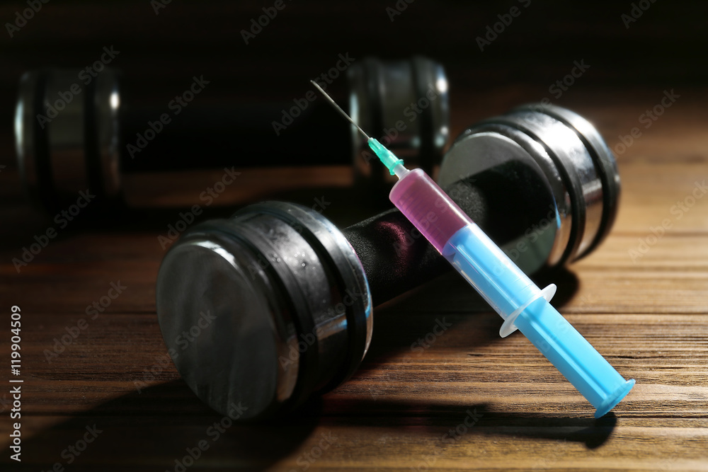 Syringe and dumbbells. Doping in sport concept Syringe and dumbbells. Doping in sport concept