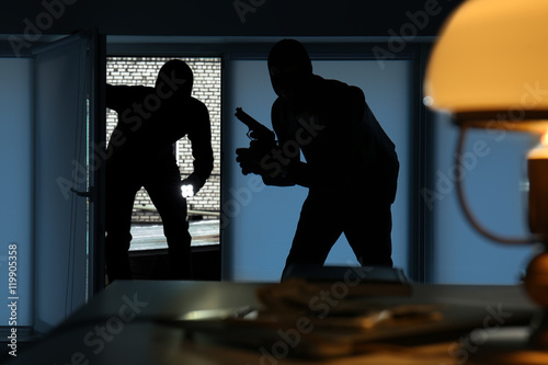 Fotografia Armed thieves entering a house