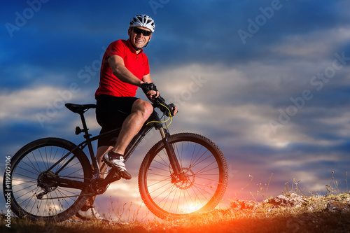 mountain bicycle rider on the hill with sunrise background