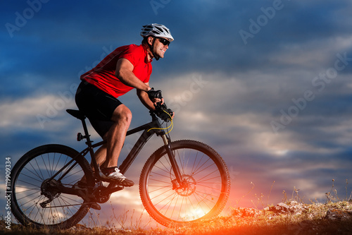 mountain bicycle rider on the hill with sunrise background