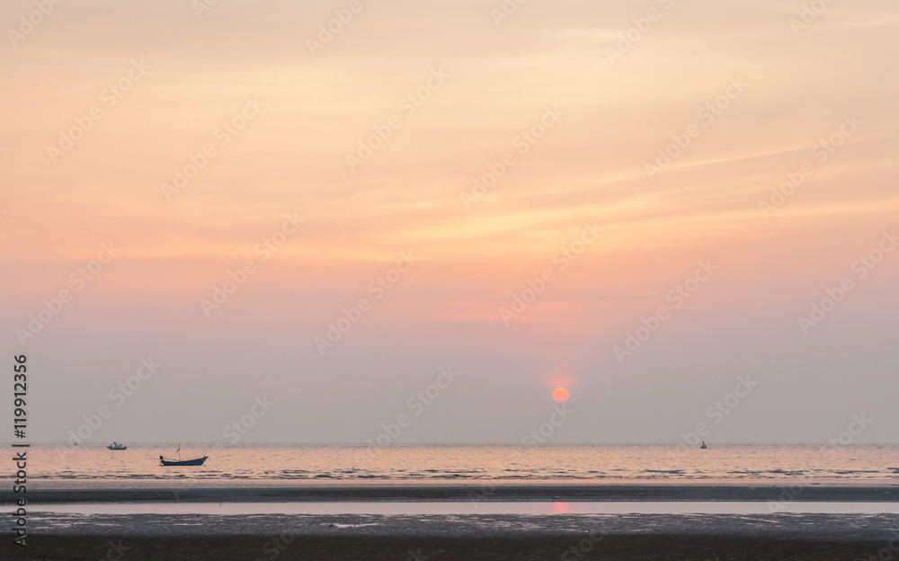 Obraz premium Sunset on the beach with fisherman’s boats background.