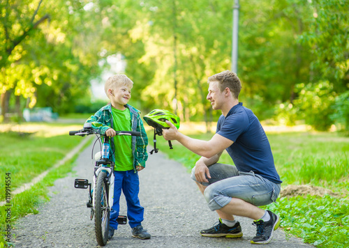 father talking with his son riding a bicycle