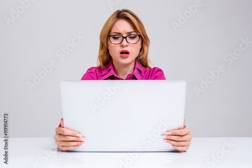 young woman sitting in the table and using laptop