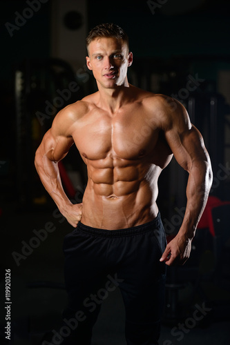 Strong athletic man fitness model showing six pack abs