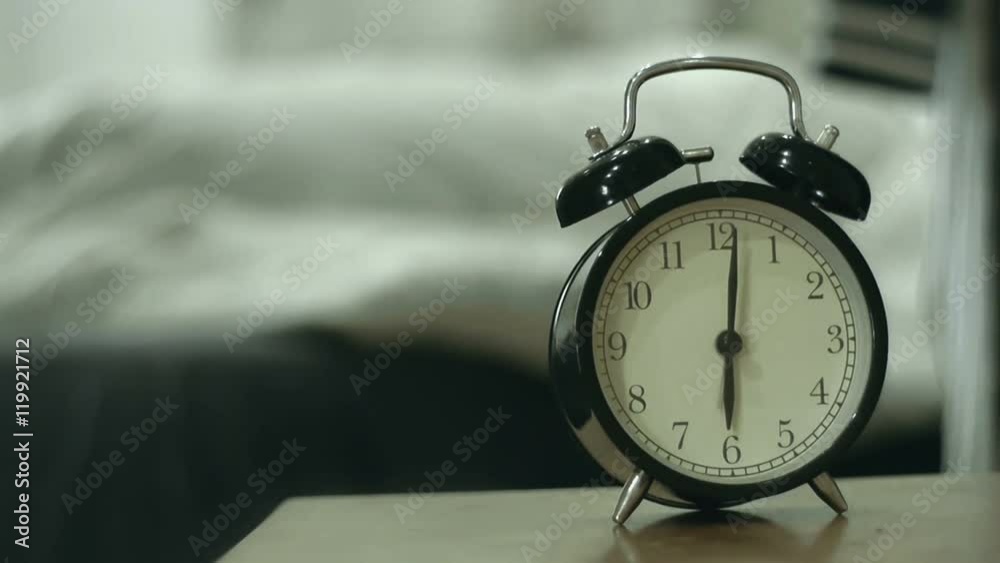 Woman and dog waking up by alarm clock at 6 o'clock in the morning 