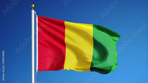Obraz na plátne Guinea flag waving against clean blue sky, close up, isolated with clipping path