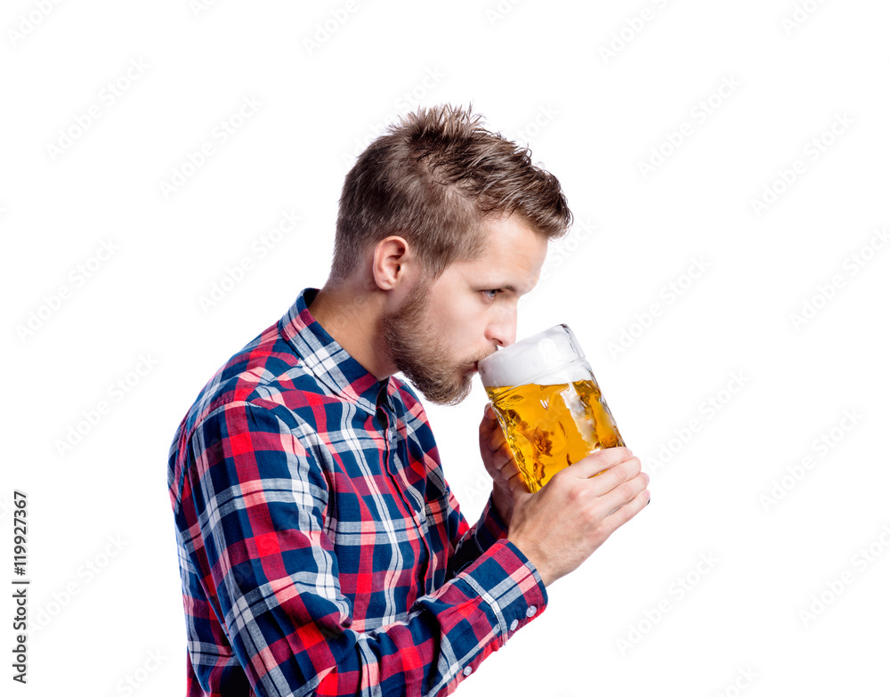 Hipster man in checked shirt drinking beer, studio shot Hipster man in checked shirt drinking beer, studio shot