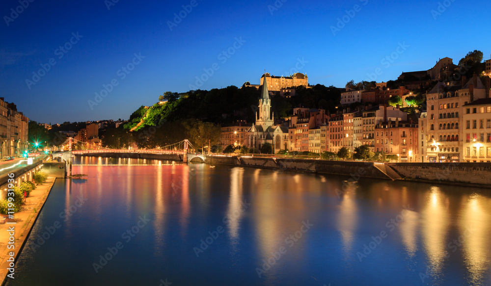 Night view over the Saone river to Passerelle Saint Georges in Lyon city.