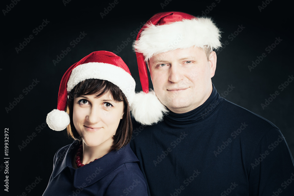 Couple in Santa Hat on Dark Background. New Year. Real People. Couple in Santa Hat on Dark Background. New Year. Real People.