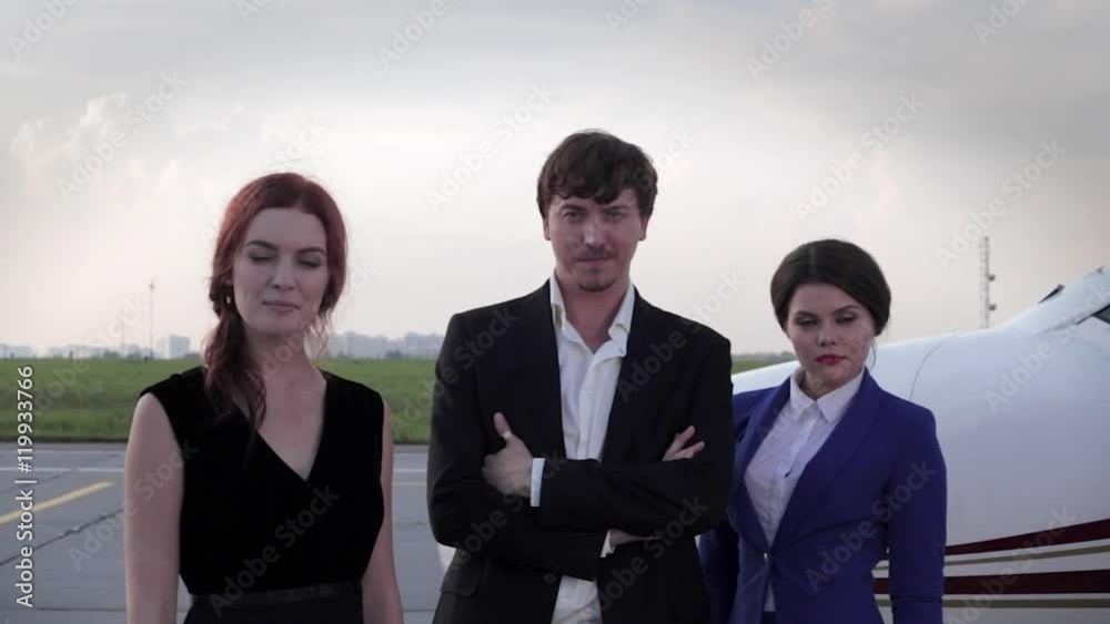 Businessman With Partner Girl and a Flight Attendant Standing at the Airport Businessman With Partner Girl and a Flight Attendant Standing at the Airport
