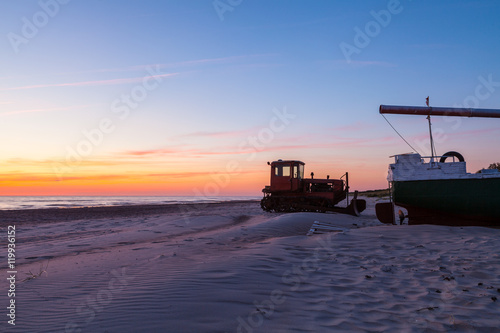Fishing boat and tractor at sunset