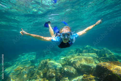 Female apnea swims in tropical turquoise sea of Racha Noi, Phuket in Thailand.