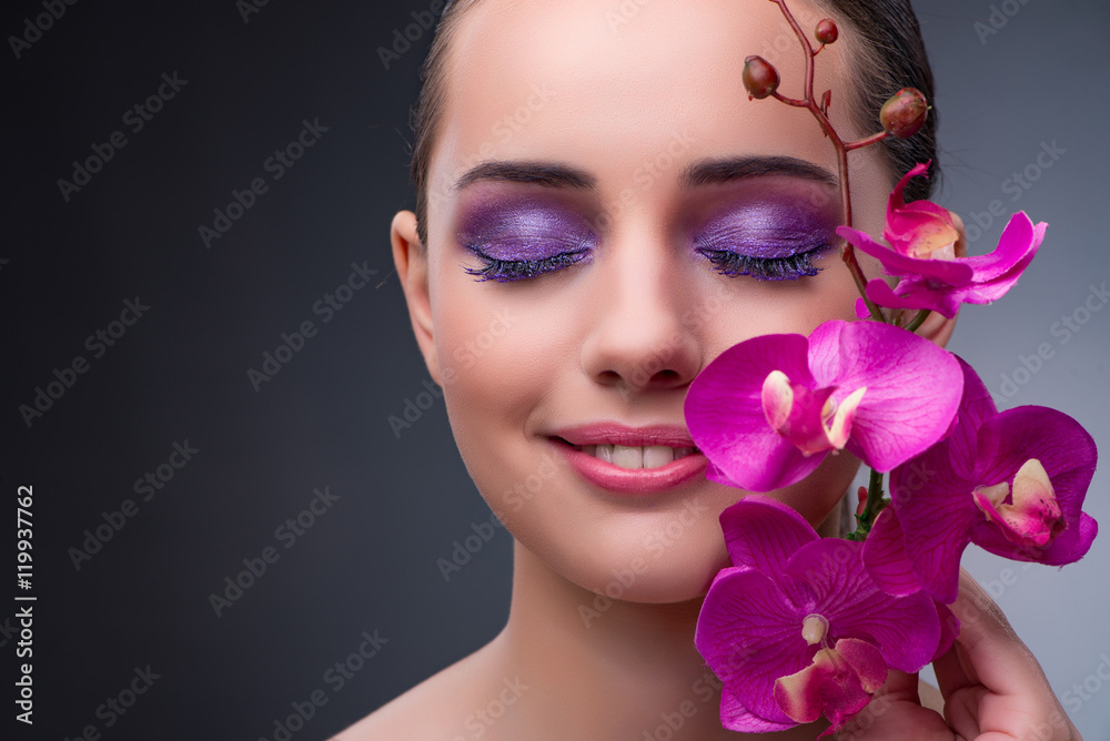 Young woman in beauty concept with orchid flower Young woman in beauty concept with orchid flower