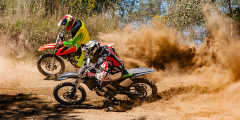 Fototapete Motorsport Motocross-Fahrer rasen um die Ecke  © KopoPhoto