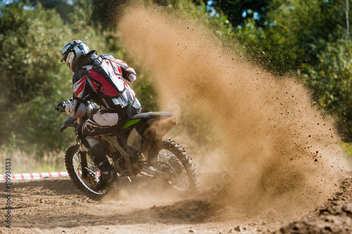 Jeździec Motocross tworzy dużą chmurę pyłu i gruzu
