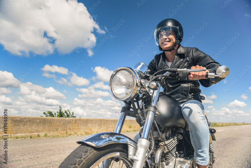 Young man riding his motorbike on open road Young man riding his motorbike on open road