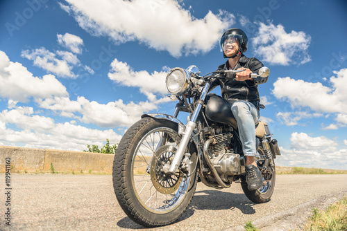 Fototapeta Naklejka Na Ścianę i Meble -  Young man riding his motorbike on open road