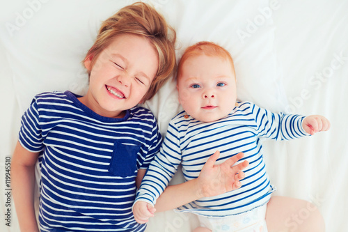 top view of brothers having fun lying in bed at home