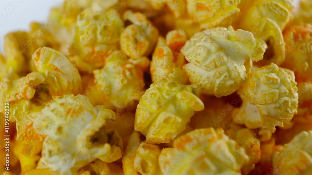 Cheese popcorn in box on white background, rotation, very close up Cheese popcorn in box on white background, rotation, very close up