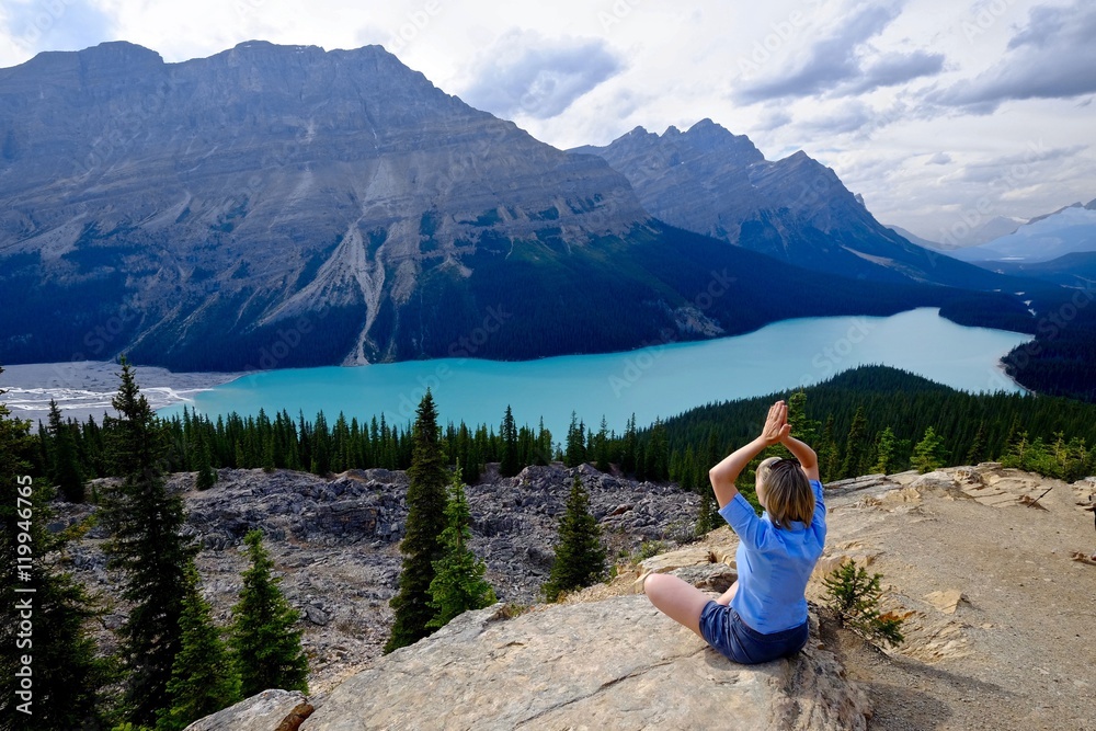 Woman relaxing by lake and mountains. Peyto  Lake  in Canadian Rockies. Banff National Park. Alberta. Canada. 