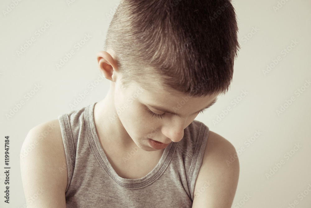 Contemplative boy in gray sleeveless shirt Contemplative boy in gray sleeveless shirt