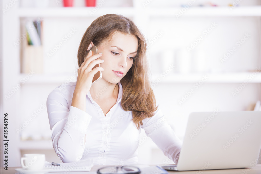 Woman on phone using laptop Woman on phone using laptop