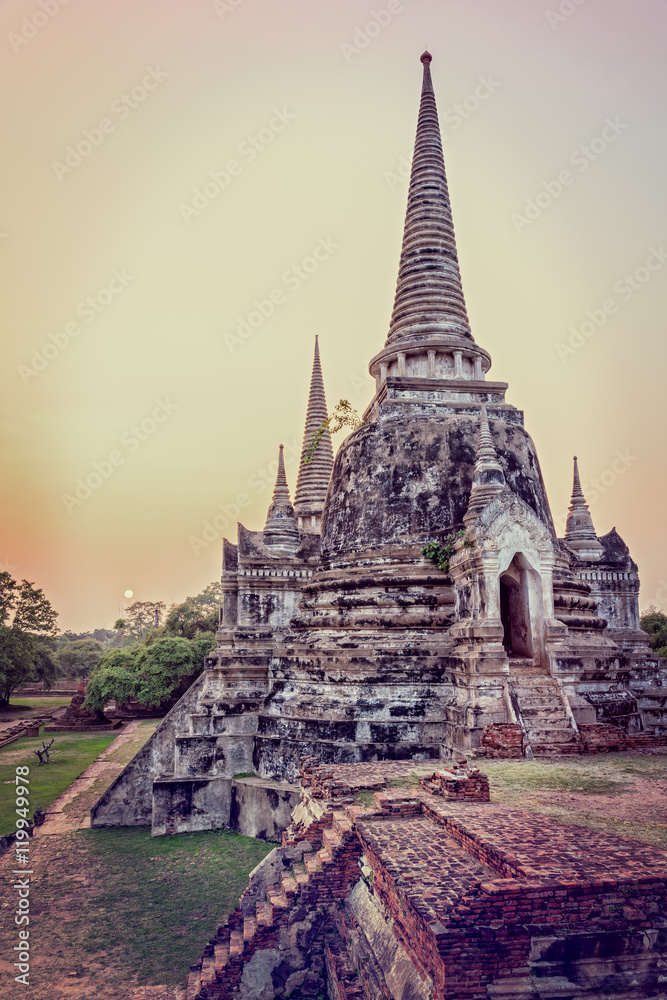 Fototapeta premium Vintage style add texture effect, ancient ruins and pagoda of Wat Phra Si Sanphet old temple famous attractions during sunset at Phra Nakhon Si Ayutthaya Historical Park, Ayutthaya Province, Thailand