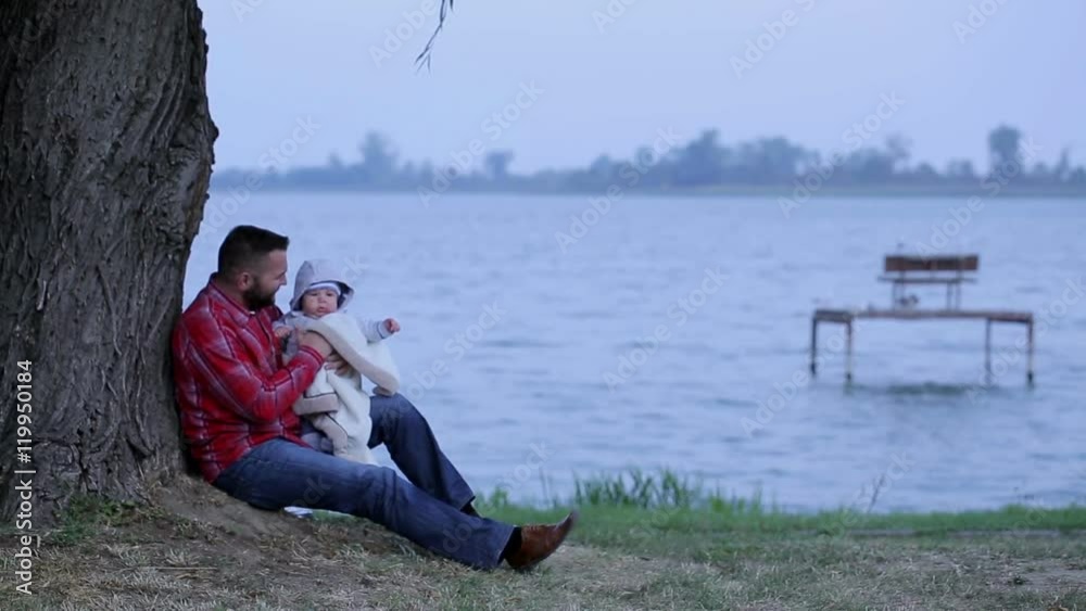 Father with little son is sitting near lake
Father with little son is sitting near lake