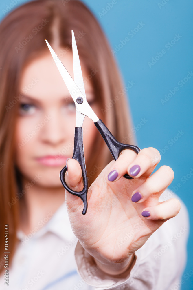 Dangerous lady showing scissors. Photos Adobe Stock