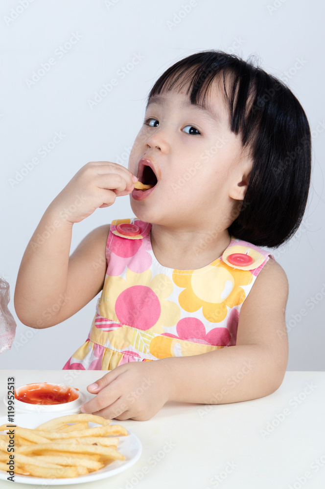 Asian Chinese little girl Eating French fries Asian Chinese little girl Eating French fries