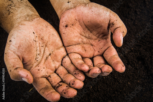 Hands dirty with clay , soil background