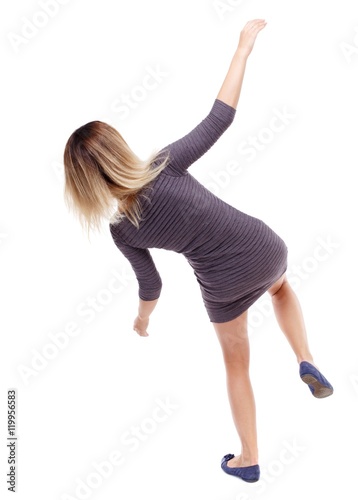 Balancing young woman. or dodge falling woman. Isolated over white background. Blonde in violet short dress falls to the side.