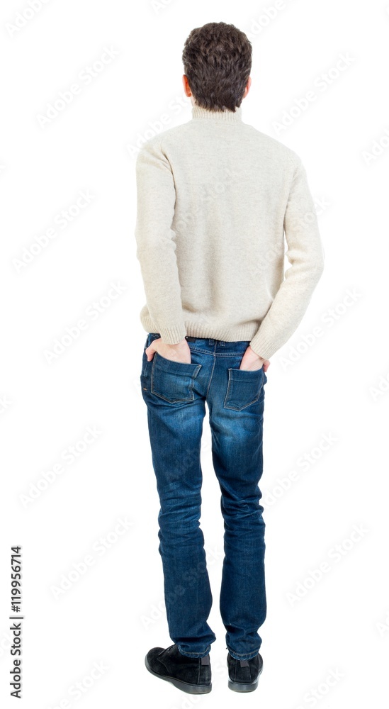 Back view of man . Curly short-haired man in a woolen white jacket standing with his hands in his pockets. Back view of man . Curly short-haired man in a woolen white jacket standing with his hands in his pockets.