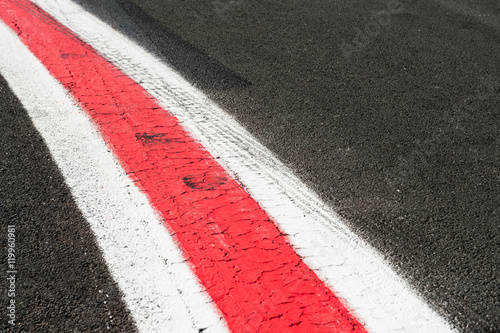 Turning red and white lines on dark grey asphalt © fabioderby