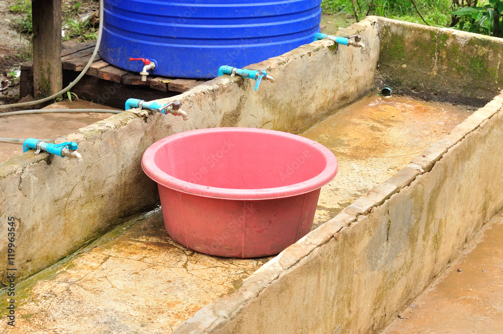 Old plastic basin in cement sink for cleaning Old plastic basin in cement sink for cleaning
