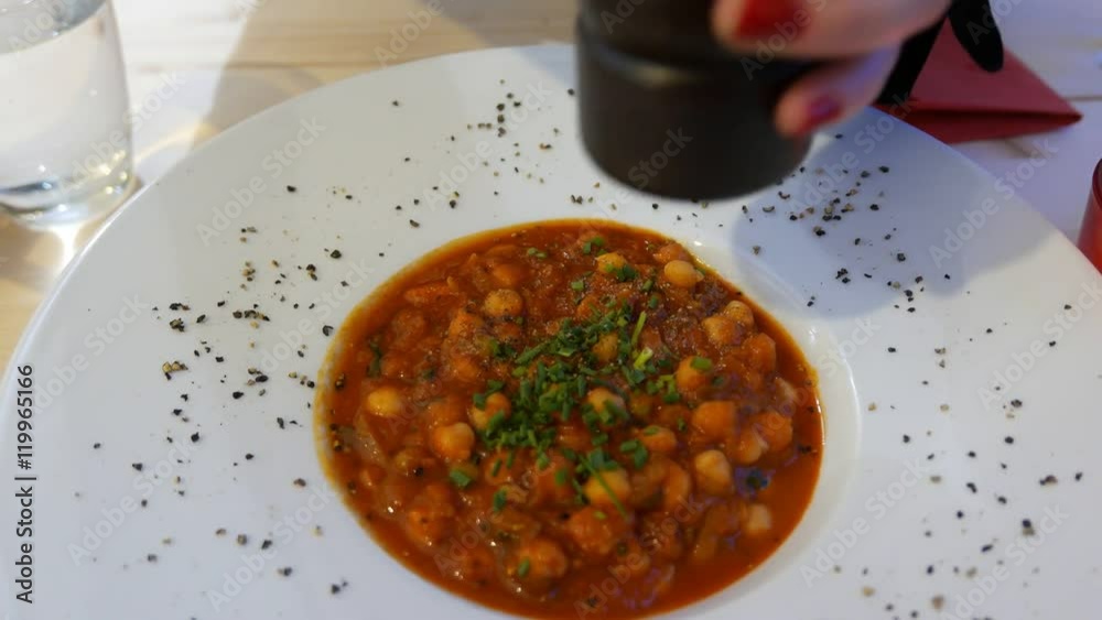 Adding pepper to a chickpeasoup