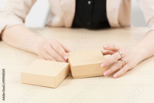 Woman holding two carton boxes on table. Female hands with post packages, preparing to open. Delivery service. online shopping, parcel opening concept © golubovy