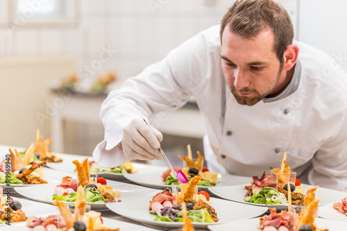 Chef garnishing his appetizer plate photo