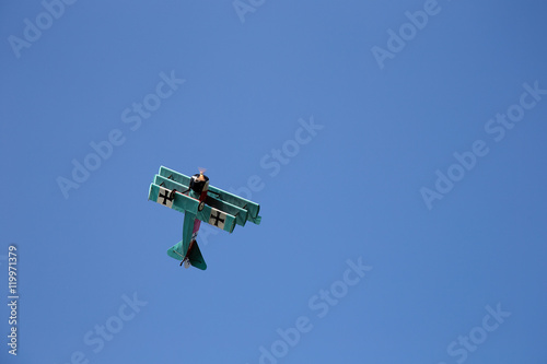 Billede på lærred Old Triplane flying on clear blue Sky - WWI Fokker
