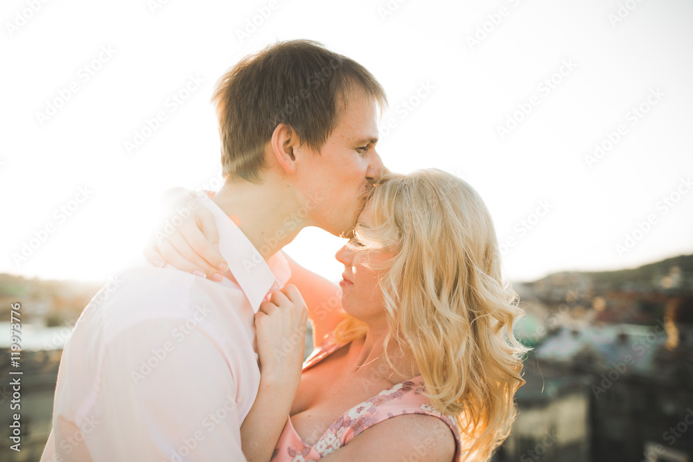 Close up portrait of happy smiling couple in love posing on roof with big balls. Landscape city Close up portrait of happy smiling couple in love posing on roof with big balls. Landscape city
