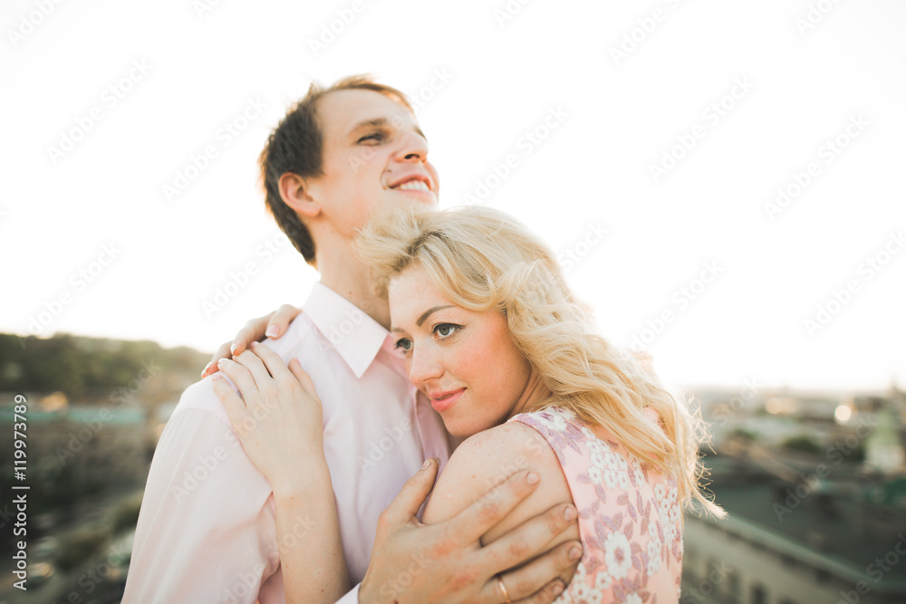 Close up portrait of happy smiling couple in love posing on roof with big balls. Landscape  city