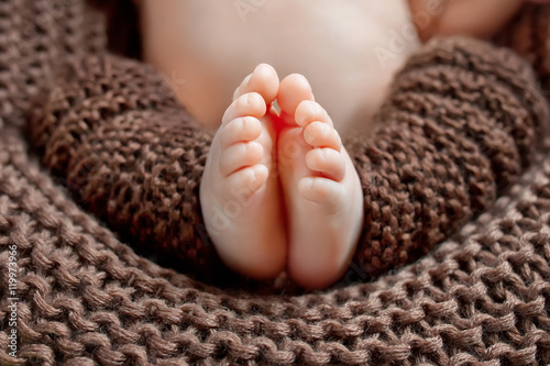 Close up picture of new born baby feet on knitted plaid