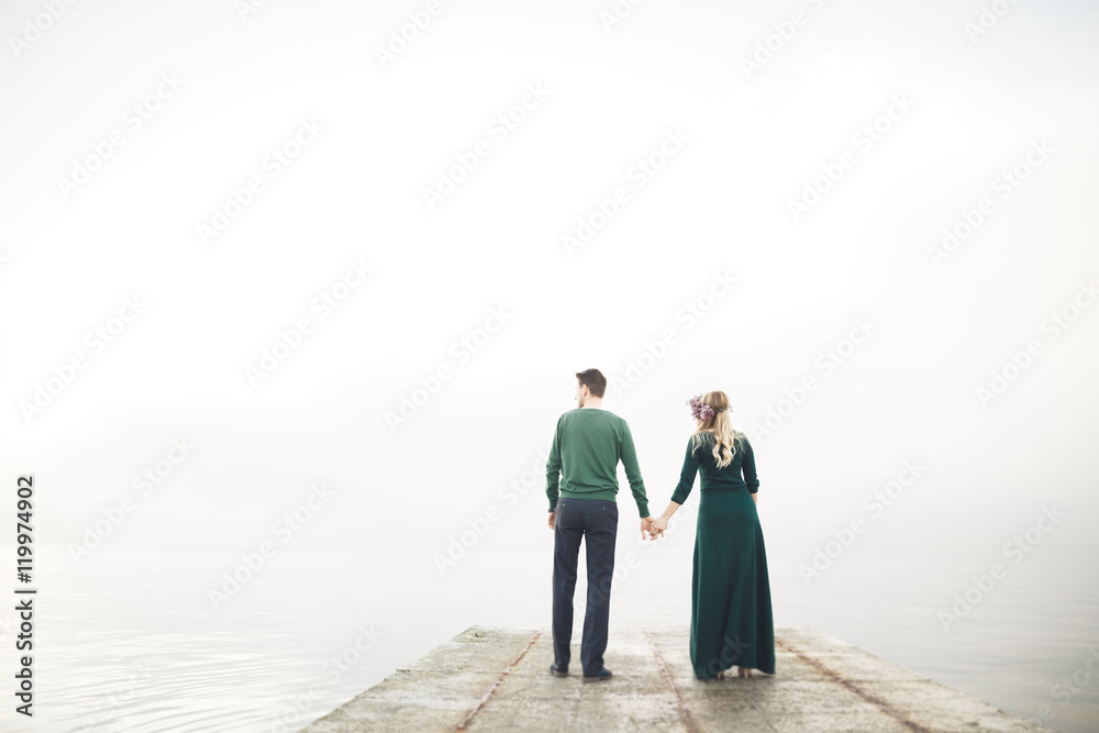 Lovely couple kissing and hugging on a sea dock