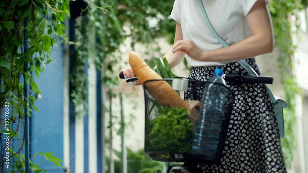 Girl walking with her bicycle and checking shopping in the basket, steadycam shot
Girl walking with her bicycle and checking shopping in the basket, steadycam shot