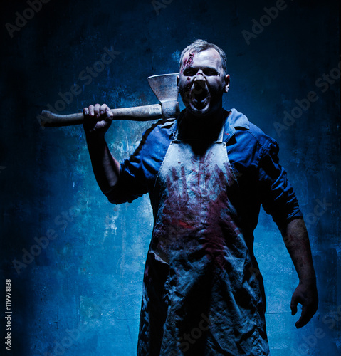 Bloody Halloween theme: crazy killer as butcher with an ax photo
