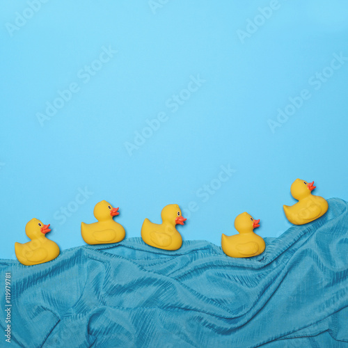 Five rubber ducks swimming in lake made of waving silk - Trendy photo