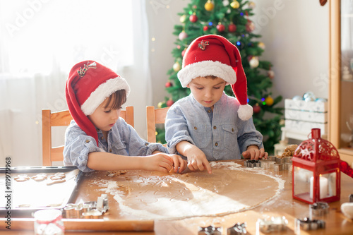Two cute boys with santa hat  preparing cookies at home  Christm