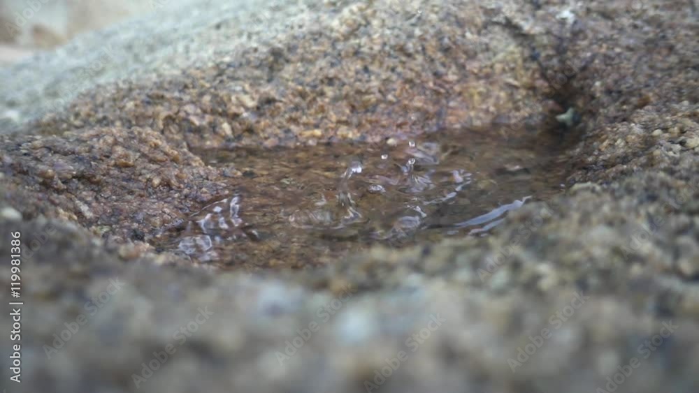 Water droplets drip into a puddle in a stone. Slow motion Water droplets drip into a puddle in a stone. Slow motion