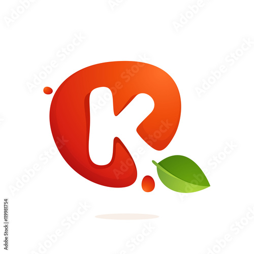 Letter K logo in fresh juice splash with green leaves.