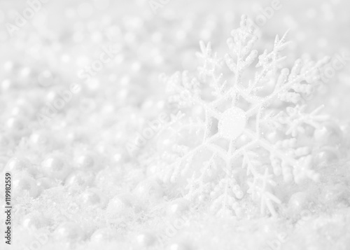 white winter background with glittering snowflake on foreground, artificial snow and beads for Christmas tree decoration © Maria Raz